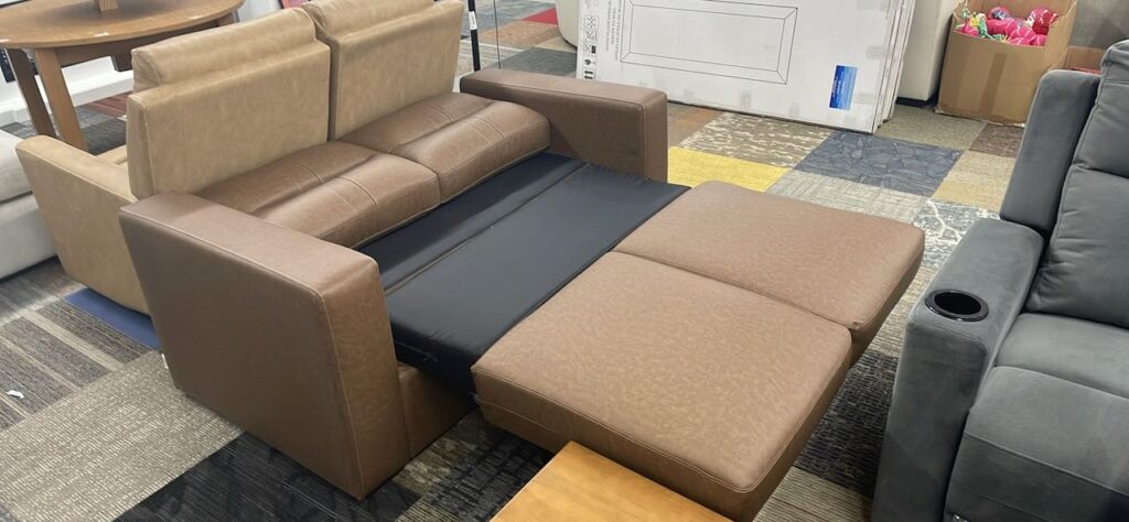 Brown leather mini couch makes into bed